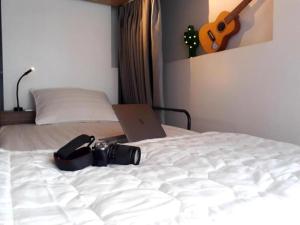 een bed met een camera en een laptop erop bij Adora Dorm Bed with Balcony in the Center in Can Tho