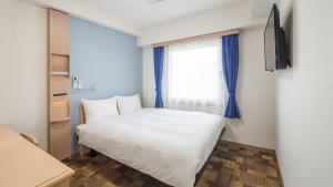 Postel nebo postele na pokoji v ubytování Toyoko Inn Chigasaki Shiyakusho