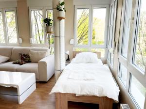 Habitación con cama, sofá y ventanas. en Workers Apartment in Offenbach, en Gravenbruch