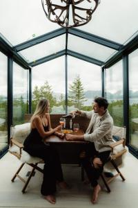 un homme et une femme assis à une table avec des boissons dans l'établissement WonderInn Arctic, à Utstrand