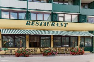 a restaurant with tables and chairs in front of a building at ALPINE Appartement 208 Schladming by globboard in Schladming