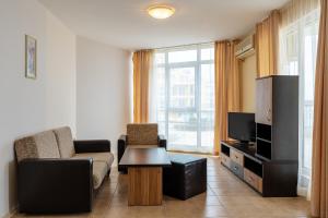 a living room with a couch and a tv at Apartments in Midia Family Resort in Aheloy