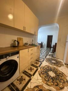 a kitchen with a washing machine on a tile floor at Good night in Tbilisi City