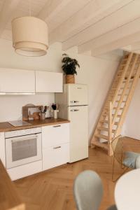 uma cozinha com armários brancos e uma escadaria em Men Louet E - Gîte de bord de mer em Ploudalmézeau