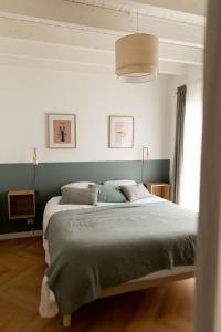 um quarto com uma cama grande e lençóis verdes em Men Louet E - Gîte de bord de mer em Ploudalmézeau