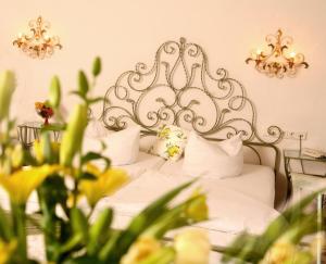 a bedroom with a bed with white sheets and pillows at Seibel's Park Hotel in Munich
