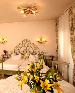 a bedroom with a bed with yellow flowers on a table at Seibel's Park Hotel in Munich