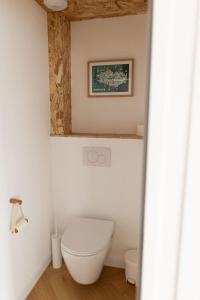 baño con aseo y una foto en la pared en Men Louet E - Gîte de bord de mer, en Ploudalmézeau