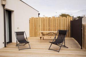 2 chaises et une table en bois sur la terrasse dans l'établissement Men Louet E - Gîte de bord de mer, à Ploudalmézeau