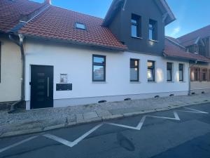 a white building with a black door on a street at Stilapartment Oasis 1 #Whirlpool saisonal in Wernigerode