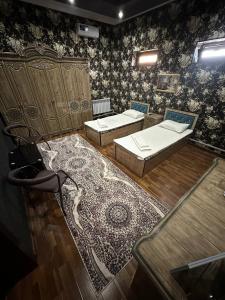 Habitación con 2 camas y alfombra. en TURKISTAN Hotel en Kogon
