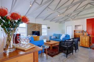 ein Wohnzimmer mit einem blauen Sofa und einem Tisch in der Unterkunft Jolie Beach Apartment in Wilderness