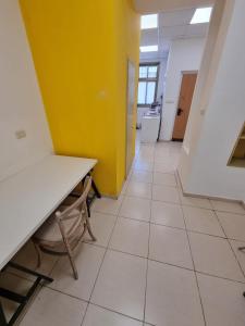 a hallway of an office with a yellow wall and a table at Fellini 8 1/2 in Haifa