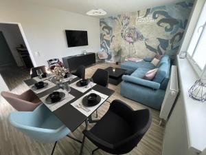 a living room with a table and a blue couch at Stilapartment Oasis 1 #Whirlpool saisonal in Wernigerode