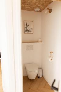 a bathroom with a white toilet in a room at Men Louet O - Gîte de bord de mer in Ploudalmézeau