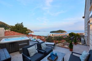 a balcony with chairs and a hot tub and the ocean at New & Stunning Views in Luxury 5* Divona Apartment in Dubrovnik