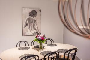 a table with chairs and a vase of flowers on it at Arctic Holiday Apartments 2 in Rovaniemi