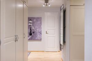 a hallway with a white door and a painting on the wall at Arctic Holiday Apartments 2 in Rovaniemi