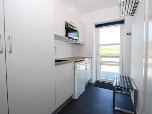 a small kitchen with white cabinets and a window at 2 person holiday home in Nex in Neksø
