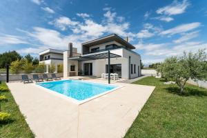 eine Villa mit einem Swimmingpool vor einem Haus in der Unterkunft Villa Marita 2 in Privlaka