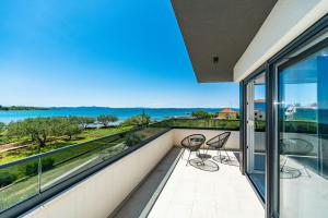 ein Balkon mit zwei Stühlen und Blick auf das Meer in der Unterkunft Villa Marita 2 in Privlaka