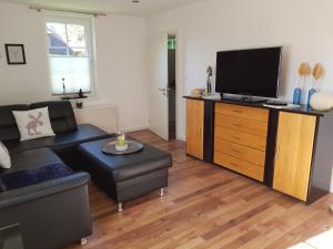 a living room with a couch and a flat screen tv at Ferienwohnung Südheide in Beedenbostel