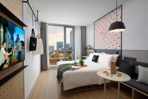 a hotel room with a bed and a tv at lyf by Ascott Hongqiao Shanghai NECC in Shanghai