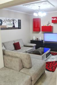 een woonkamer met een bank en een tv bij Essy's Apartment in Korçë