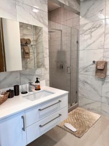 a bathroom with a white sink and a shower at Seafront Luxury Condo in Rosarito with Pool & Jacuzzi in Rosarito