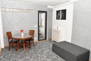 um quarto com uma mesa e uma cama e uma mesa e cadeiras em Apartament Luxury - Promenada Mall em Craiova
