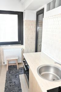 Un baño con lavabo y ventana. en Apartament Luxury - Promenada Mall, en Craiova