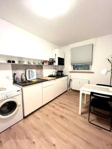 a kitchen with a washing machine and a table at X-Hain Kiezwohnung in Berlin