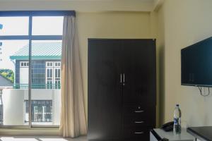 a black cabinet in a room with a window at Maaniya Residence in Maamigili