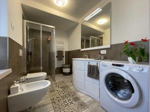 bagno con lavatrice e lavandino di 029 Trilocale Duplex, Carisolo a Carisolo