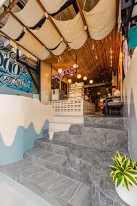 a restaurant with stairs leading up to the front of the building at Sleeper Hostel in Ao Nang Beach