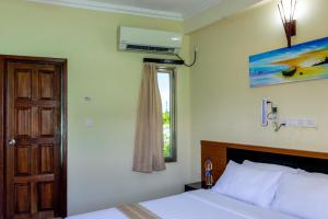 a bedroom with a bed and a window at Maaniya Residence in Maamigili