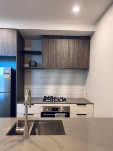 a kitchen with a sink and a stove at Anthem Stylish 1BR Apartment - with top amenities and easy airport access in Melbourne