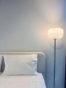 a bed with a white pillow and a lamp at Anthem Stylish 1BR Apartment - with top amenities and easy airport access in Melbourne