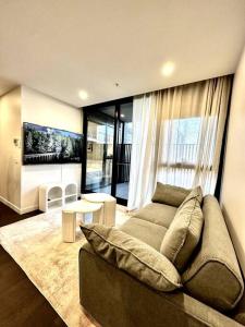 a living room with a couch and a large window at Anthem Stylish 1BR Apartment - with top amenities and easy airport access in Melbourne