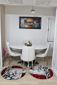 een eetkamer met een witte tafel en stoelen bij Essy's Apartment in Korçë