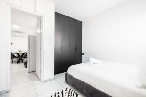 a bedroom with a white bed and a black cabinet at יחידת דיור ברמת בית מלון עם ממד in Ashdod