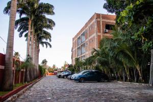 une rue pavée avec des voitures garées et des palmiers dans l'établissement Luxor garden apartments, à Accra