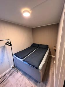 um quarto com uma cama num pequeno quarto em Leilighet sentralt i Svolvær em Svolvær