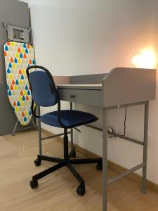 un bureau avec une chaise bleue à côté d'une table dans l'établissement 101 Beffroi, à Thionville