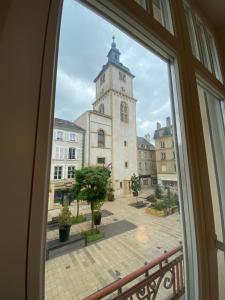una ventana con vistas a un edificio con una torre de reloj en 101 Beffroi, en Thionville