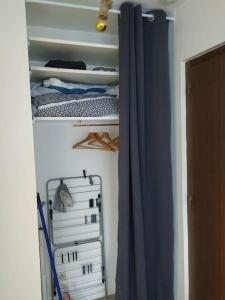 a closet with a blue curtain in a room at Le Victor-Verdure-jardin apaisant in Chartres