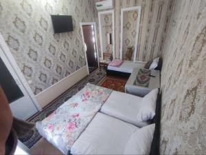 ブハラにあるMadina-Mehribon Welcome to Bukharaのベッド1台とソファが備わる小さな客室です。