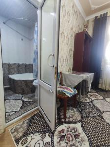 a bathroom with a toilet and a glass door at Madina-Mehribon Welcome to Bukhara in Bukhara