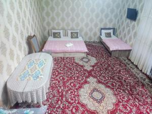 ブハラにあるMadina-Mehribon Welcome to Bukharaの赤いカーペットフロアの客室で、ベッド2台が備わります。
