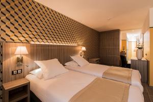 una habitación de hotel con 2 camas en una habitación en Unique Hôtel & Spa, en Saint-Raphaël
